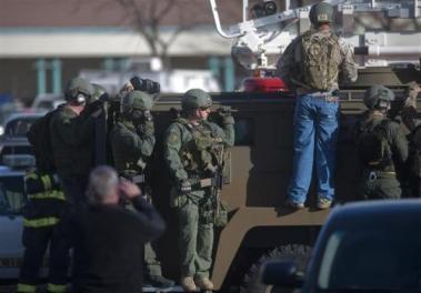 Armed law enforcement officers gather outside Arapahoe High School, after a student opened fire in the school in Centennial, Colorado